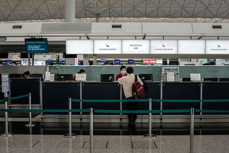 Nhân viên của Cathay Pacific nói chuyện với một hành khách tại sân bay quốc tế Hong Kong vào tháng 2/2020. Ảnh: Bloomberg