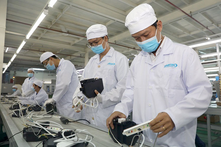 Các kỹ sư nhà máy Asanzo Bình Tân đeo khẩu trang khi làm việc. Ảnh: Hữu Khoa.