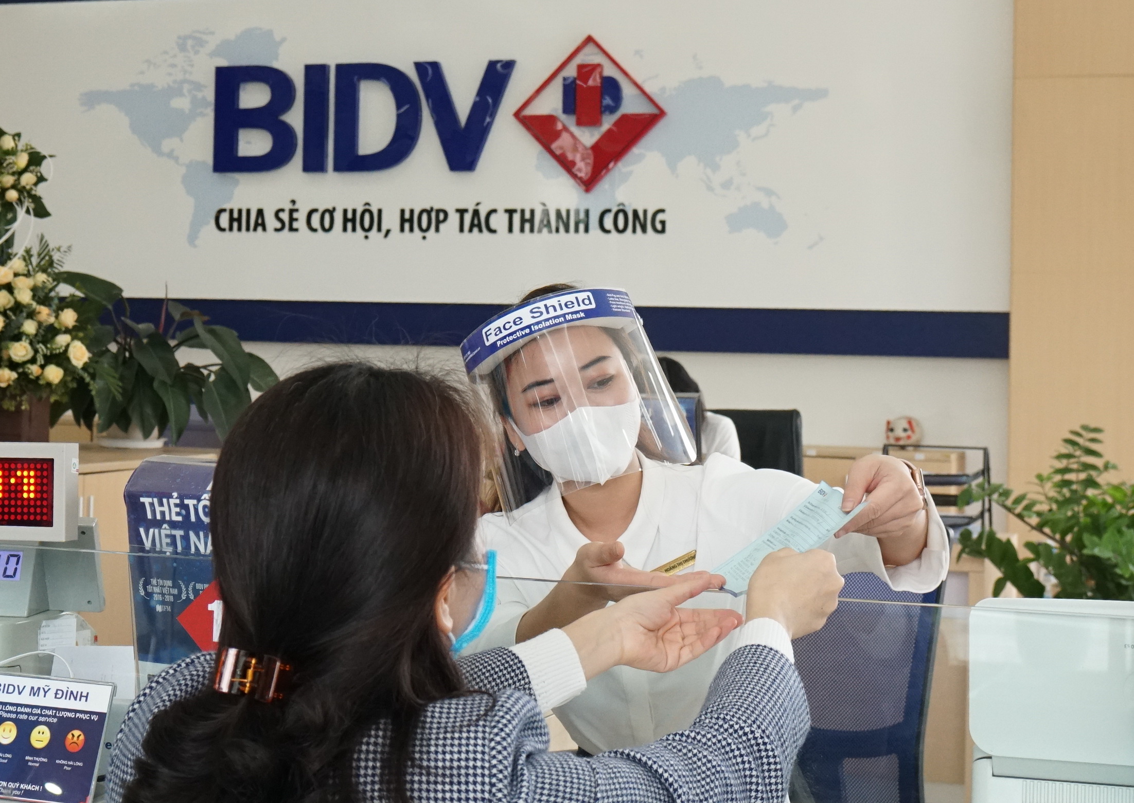 Nhân viên BIDV hướng dẫn khách hàng tới giáo dịch. Ảnh: BIDV