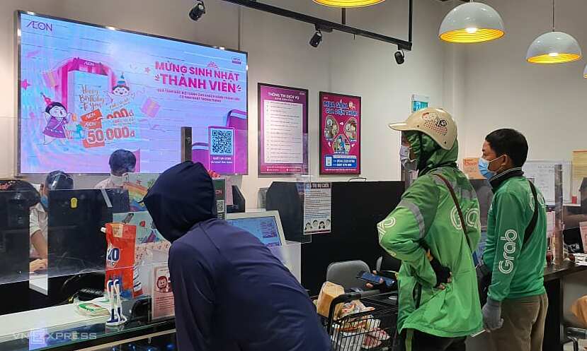 Tài xế Grab chờ nhận hàng tại siêu thị Aeon Mall Hà Đông sáng 24/7. Ảnh: Đức Minh